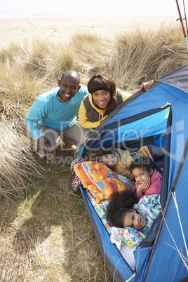 Young Family Relaxing Inside Tent On Camping Holiday