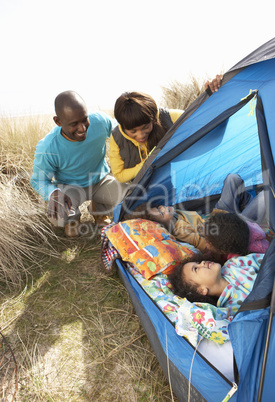 Young Family Relaxing Inside Tent On Camping Holiday