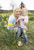 Family On Easter Egg Hunt In Daffodil Field