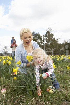 Family On Easter Egg Hunt In Daffodil Field