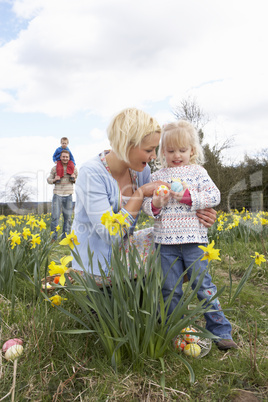 Family On Easter Egg Hunt In Daffodil Field