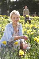 Woman Hiding Decorated Easter Eggs For Hunt Amongst Daffodils
