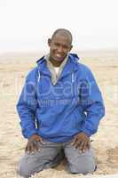Man Relaxing On Beach In Autumn Clothing