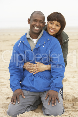 Young Couple Relaxing On Winter Beach Holiday