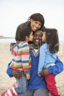 Family Relaxing On Winter Beach Break