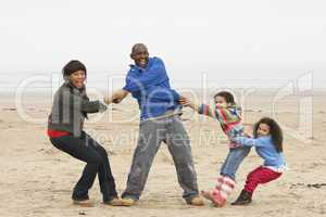 Family Having Fun On Winter Beach