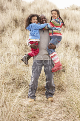 Father And Daughters Having Fun In Sand Dunes