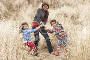 Mother And Daughters Having Fun In Sand Dunes