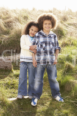 Boy And Girl Playing In Field Together