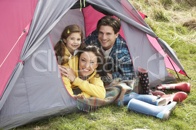 Young Family Relaxing Inside Tent On Camping Holiday