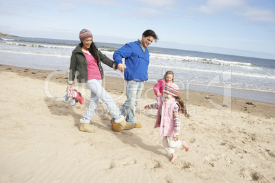 Family Walking Along Winter Beach