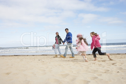 Family Walking Along Winter Beach