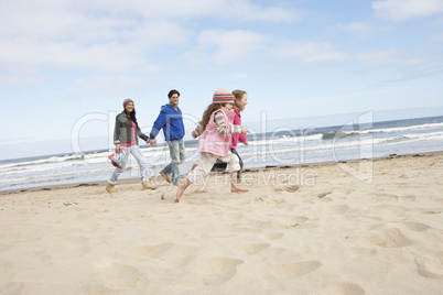 Family Walking Along Winter Beach