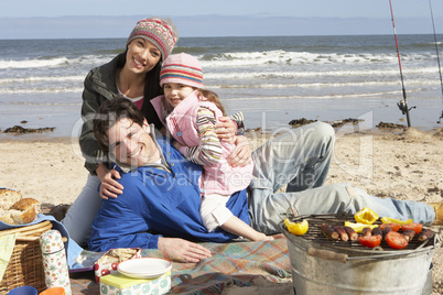 Family Having Barbeque On Winter Beach