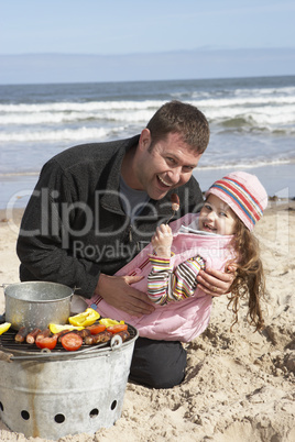 Father And Daughter Having Barbeque On Winter Beach