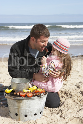 Father And Daughter Having Barbeque On Winter Beach