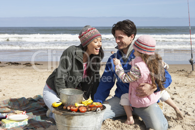 Family Having Barbeque On Winter Beach