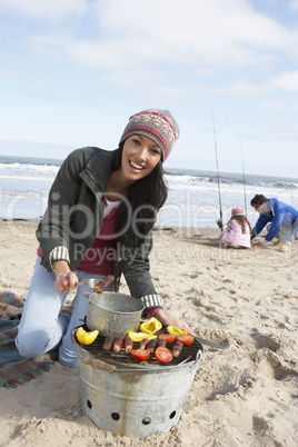 Family Having Barbeque On Winter Beach