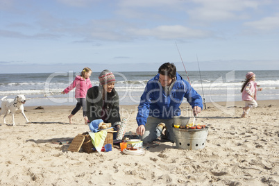 Family Having Barbeque On Winter Beach