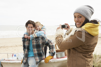 Mother Taking Family Photograph On Winter Beach