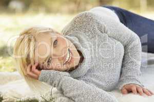 Portrait Of Attractive Young Woman Relaxing On Grass