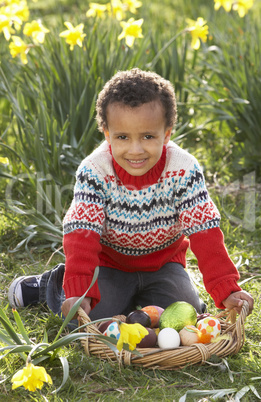 Boy On Easter Egg Hunt In Daffodil Field