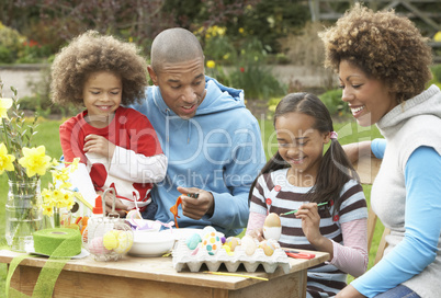 Family Painting Easter Eggs In Gardens