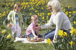 Mother And Children In Daffodil Field With Decorated Easter Eggs