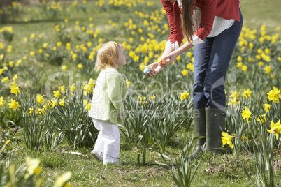 Mother And Daughter In Daffodil Field With Decorated Easter Eggs