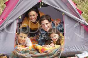 Young Family Relaxing Inside Tent On Camping Holiday