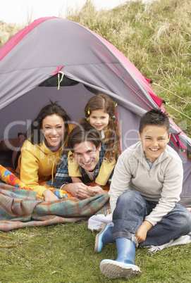 Young Family Relaxing Inside Tent On Camping Holiday