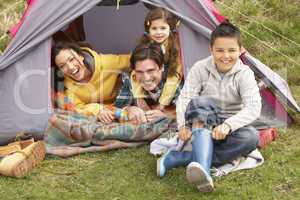 Young Family Relaxing Inside Tent On Camping Holiday