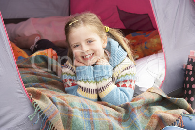 Young Girl Relaxing Inside Tent On Camping Holiday