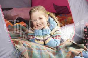 Young Girl Relaxing Inside Tent On Camping Holiday