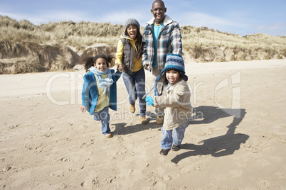 Family Running On Winter Beach