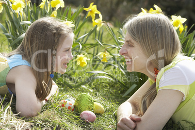 Mother And Daughter On Easter Egg Hunt In Daffodil Field