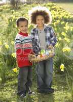 Two Boys Having Easter Egg Hunt In Daffodil Field