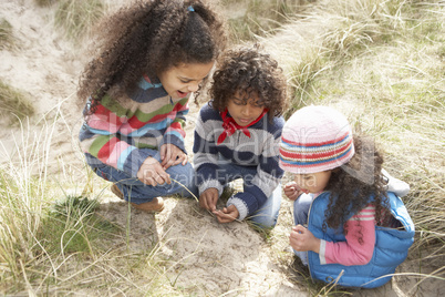 Children Playing In Dunes On Winter Beach