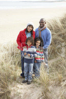 Family Walking In Dunes On Winter Beach
