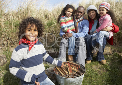 Family Having Barbeque On Winter Beach