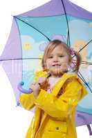 Little girl in a yellow jacket with an umbrella