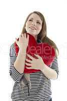 Frau kuschelt mit einem Herzkissen