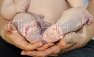 Babyfüsschen und schützende Hände