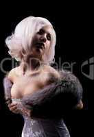 Beauty blonde posing in corset and fur boa