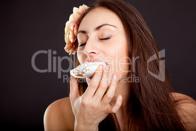 Pretty young girl with closed eyes eating cake