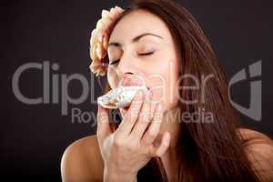 Pretty young girl with closed eyes eating cake