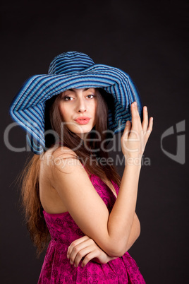 Pretty young smiling girl in cap on dark background