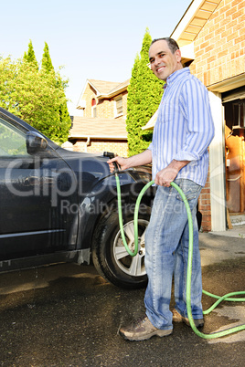 Man washing car on driveway