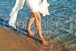 Woman in white dress walking on beach