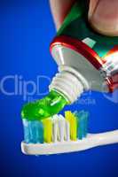toothpaste being squeezed onto a toothbrush